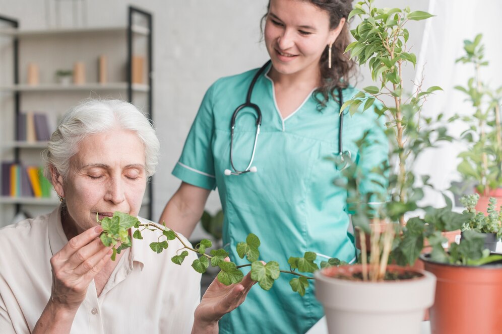 nurse-looking-senior-female-patient-smelling-ivy-plant-pot_23-2147861507 nurse-looking-senior-female-patient-smelling-ivy-plant-pot_23-2147861507