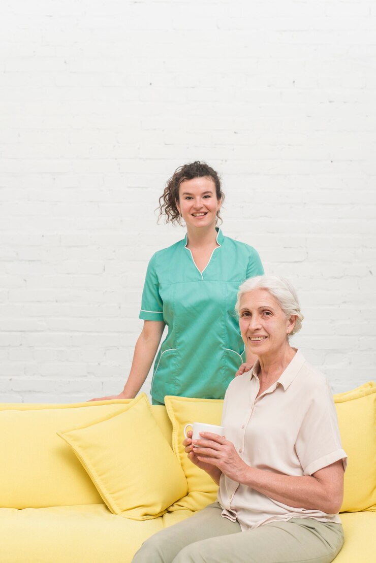 smiling-senior-woman-sitting-sofa-holding-coffee-cup-front-nurse_23-2147861584 smiling-senior-woman-sitting-sofa-holding-coffee-cup-front-nurse_23-2147861584